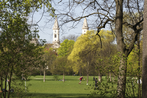 Bild: Im Englischen Garten. Im Hintergrund ist die Universitätskirche St. Ludwig zu sehen.