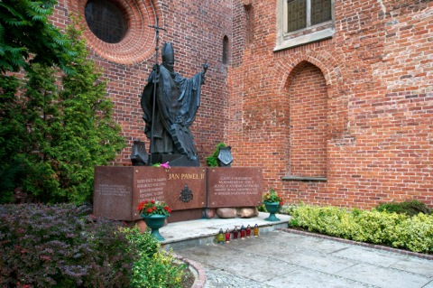 Bild: Das obligatorische Denkmal zu Ehren des Papstes Johannes Paul II. - Karol Józef Wojtyła - an der Nikolaikirche zu Elbląg - früher Elbing.