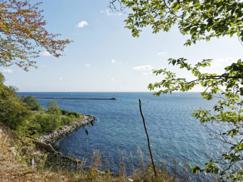 Bild: Das Steilufer am Klocker Ufer am Schloss Dwasieden in der Nähe des Hafens von Sassnitz bietet einen idyllischen Blick auf den Leuchtturm und die Prorer Wiek. Hier sollte nach dem Zweiten Weltkrieg ein Ausbildungszentrum für die U-Boot Flotte der Kasernierten Volkspolizei der SBZ und der 1949 gegründeten DDR entstehen. Klicken Sie auf das Bild um es zu vergrößern.